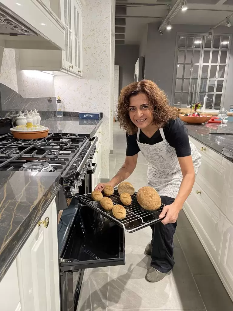 Dilek Parlak, fırından taze ekşi maya ekmeklerini çıkarıyor